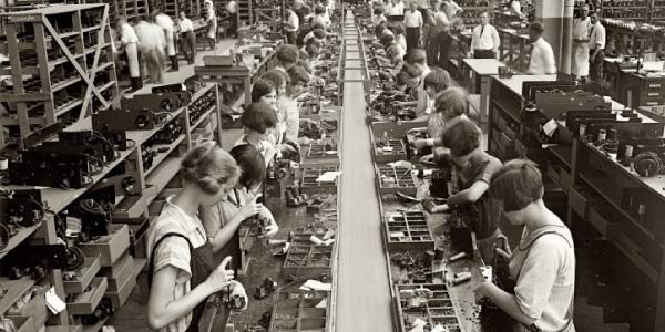 Pessoas trabalhando na linha de montagem no modelo de produção chamado fordismo
