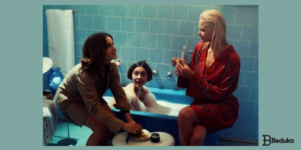 Resumo-de-As-Meninas-três-meninas-sentadas-em-torno-de-uma-banheira-no-banheiro-conversando-animadamente-.-Uma-loira-de-hobby-vermelho-uma-morena-dentro-da-banheira-e-uma-outra-sentada-no-vaso.